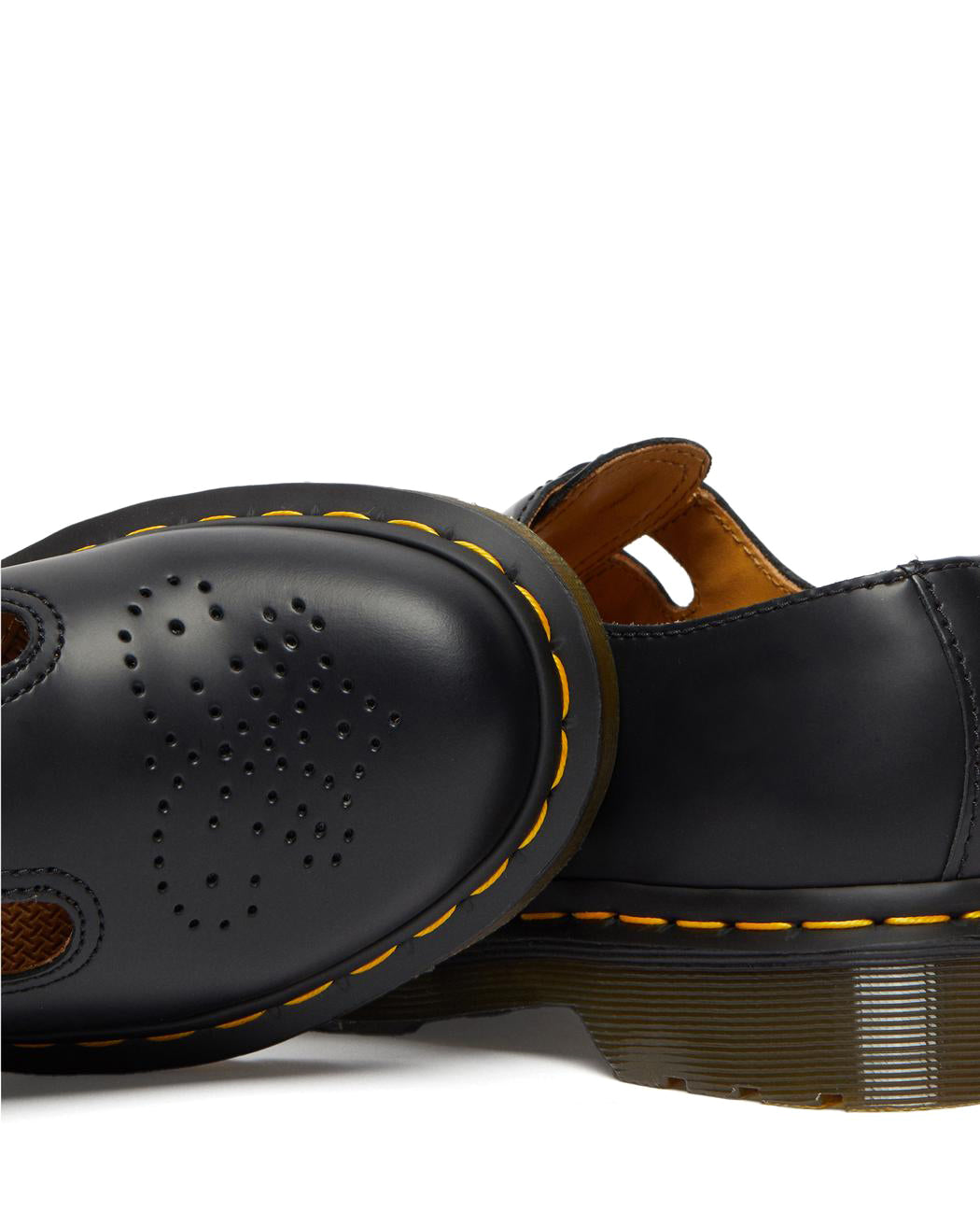A black leather Dr. Martens mary jane shoe with brass buckles.