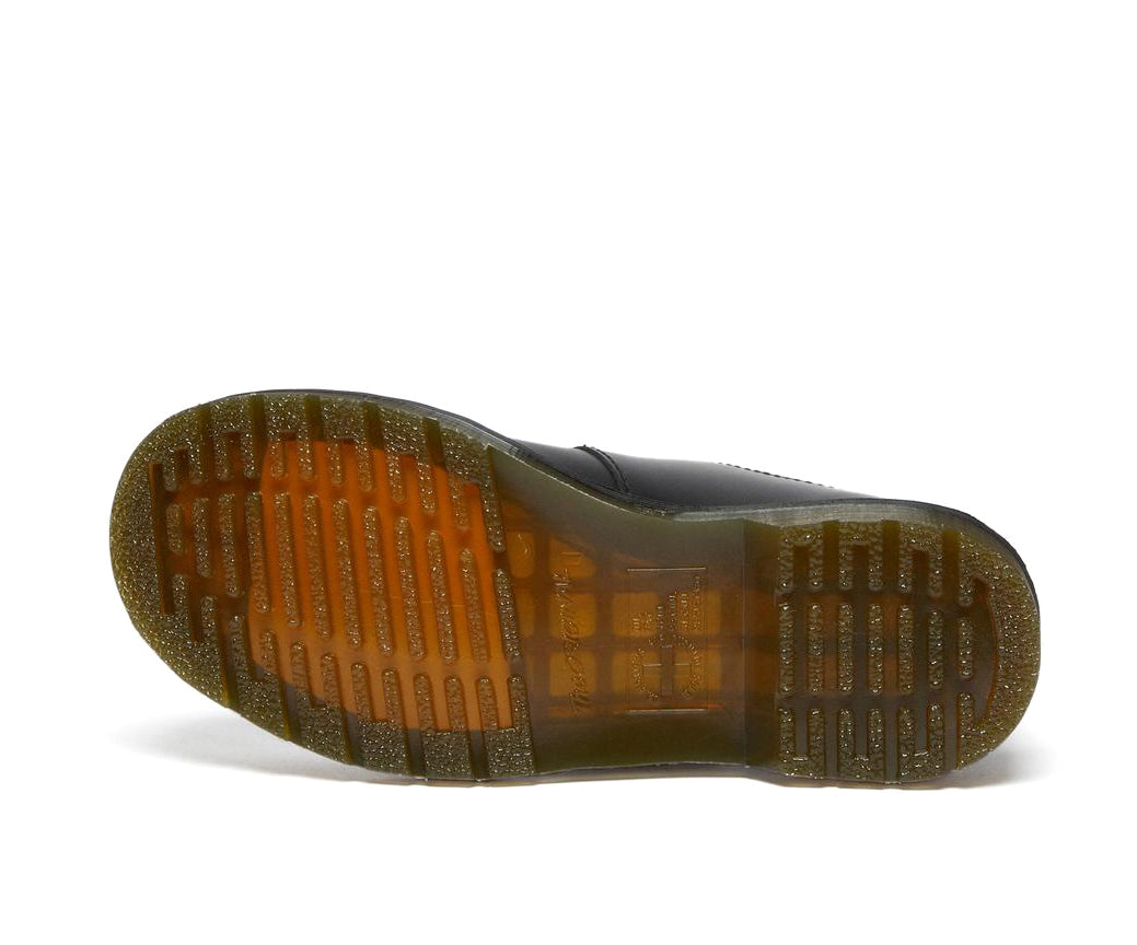 A black leather Dr. Martens mary jane shoe with brass buckles.