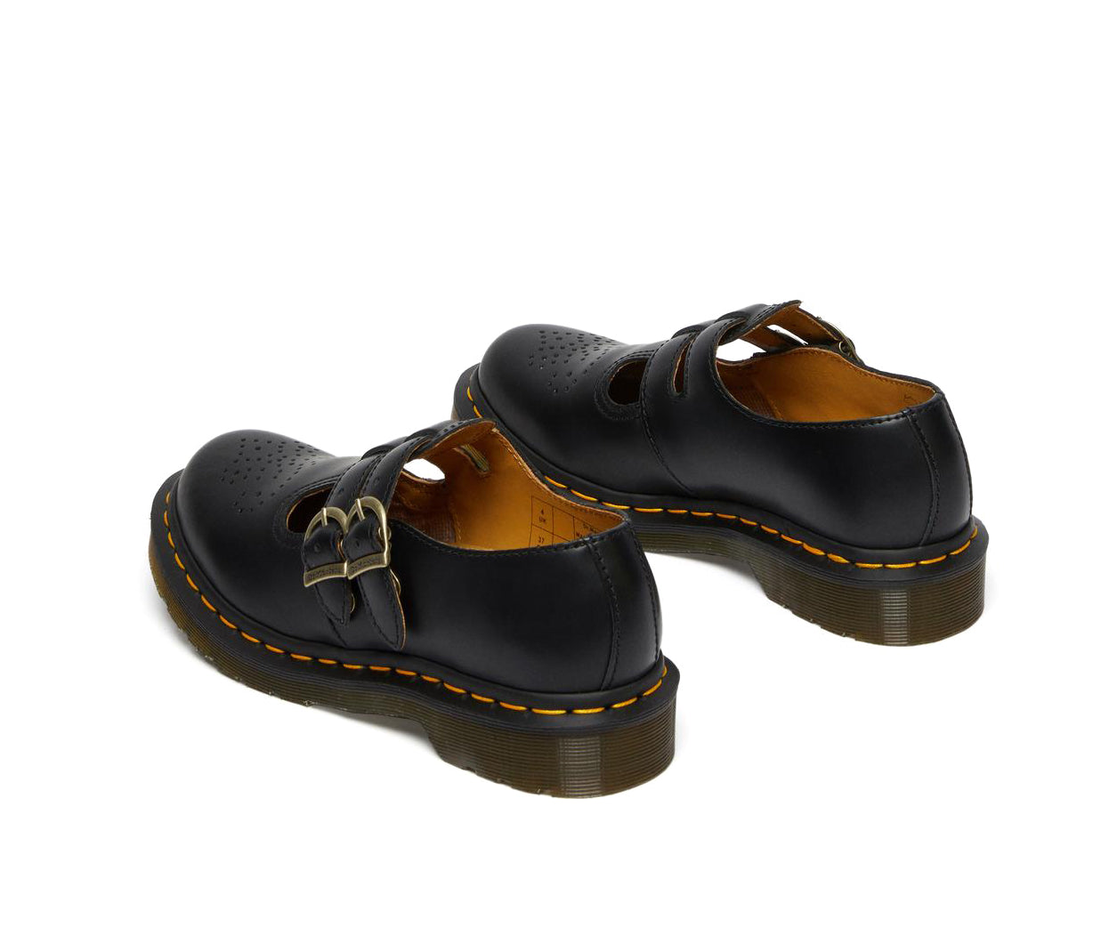 A black leather Dr. Martens mary jane shoe with brass buckles.