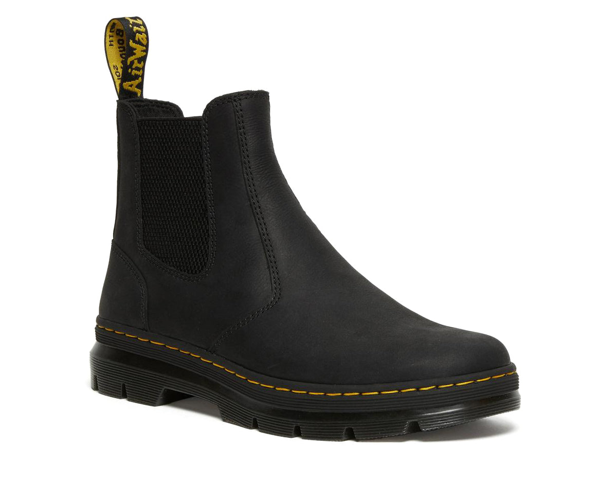 A black, softened leather chelsea boot from Dr. Martens with yellow accent stitching.