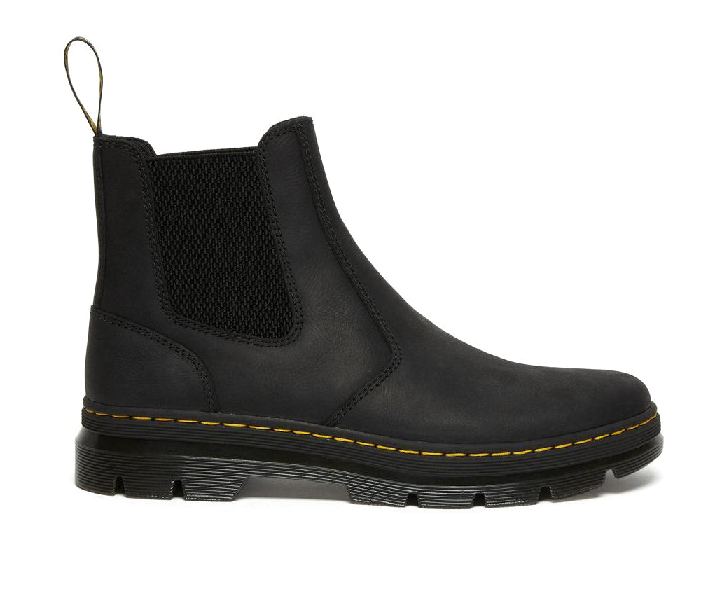 A black, softened leather chelsea boot from Dr. Martens with yellow accent stitching.