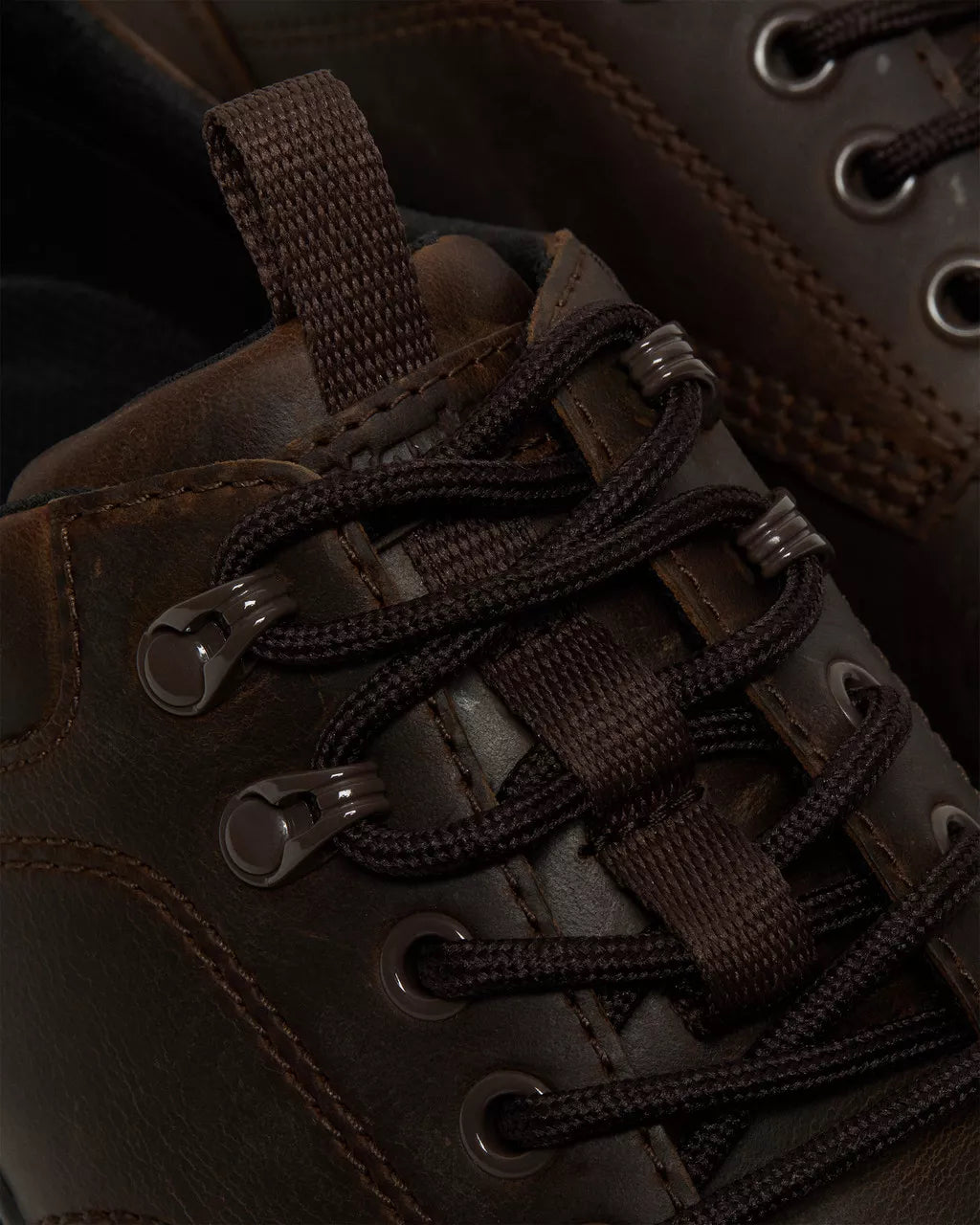 A dark brown leather shoe from Dr. Martens.