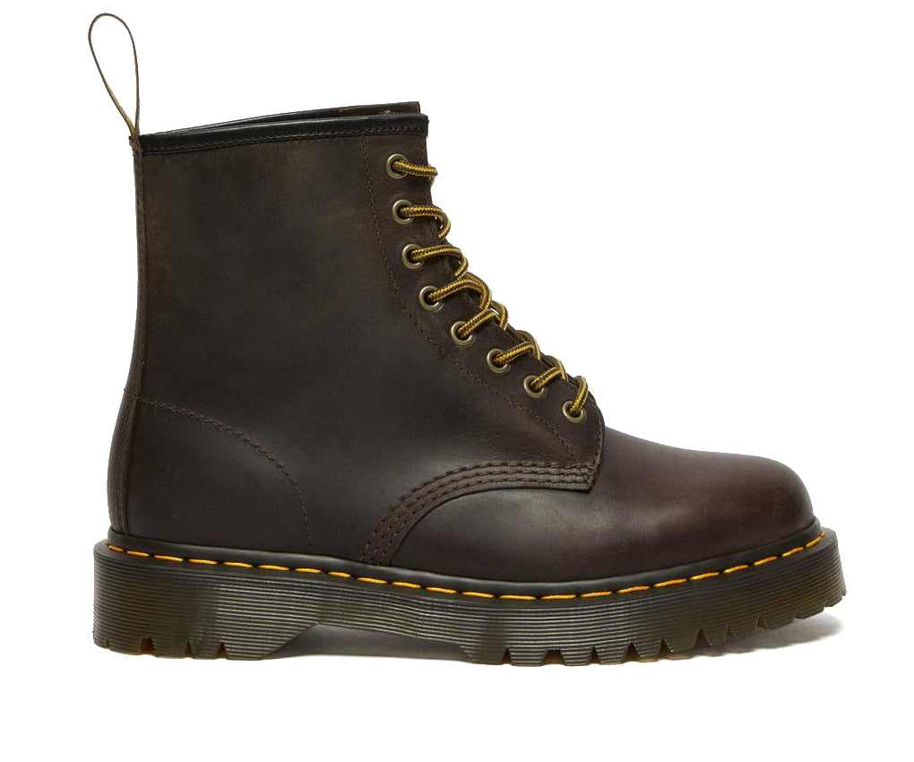 A brown leather ankle boot from Dr. Martens with yellow stitching.