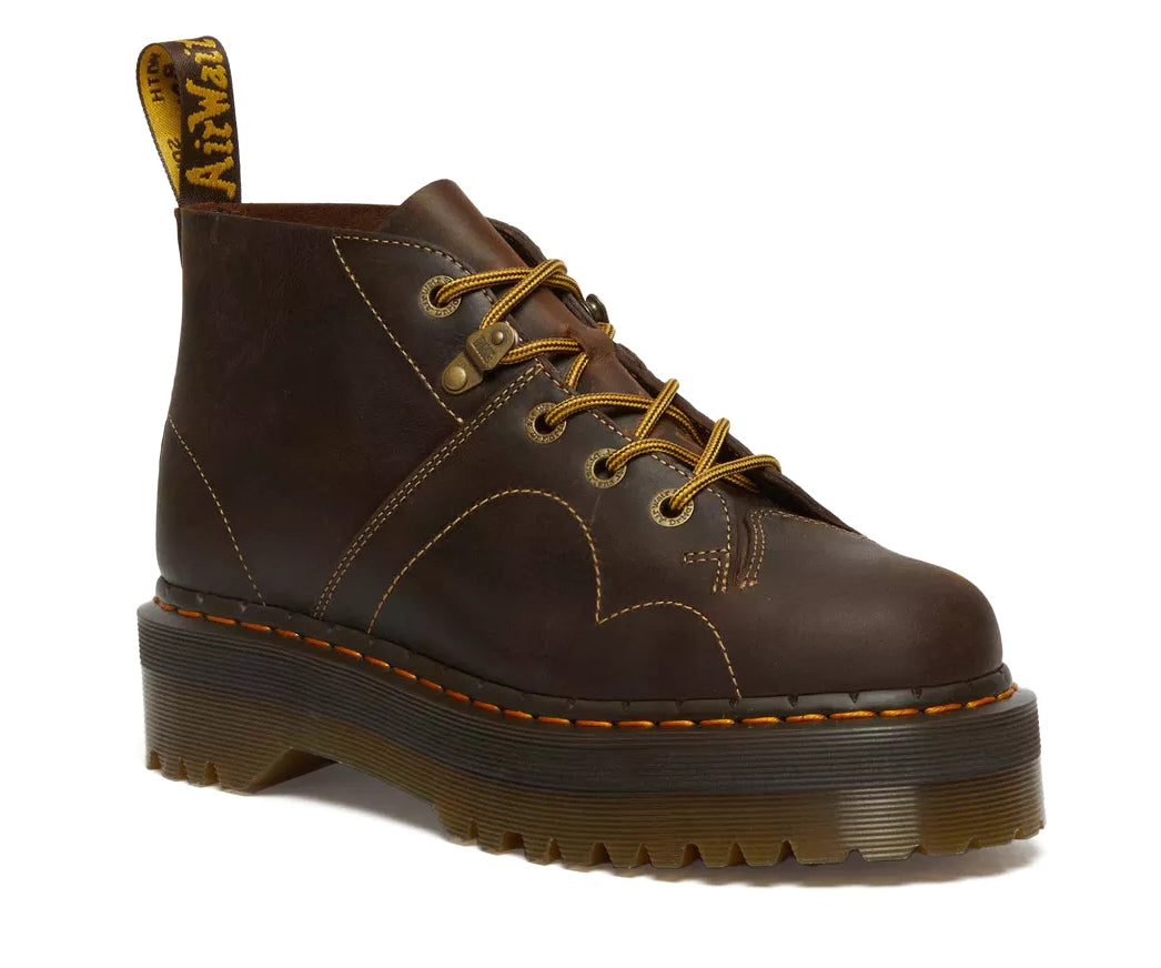 A dark brown leather chukka boot with yellow stitch accents from Dr. Martens.